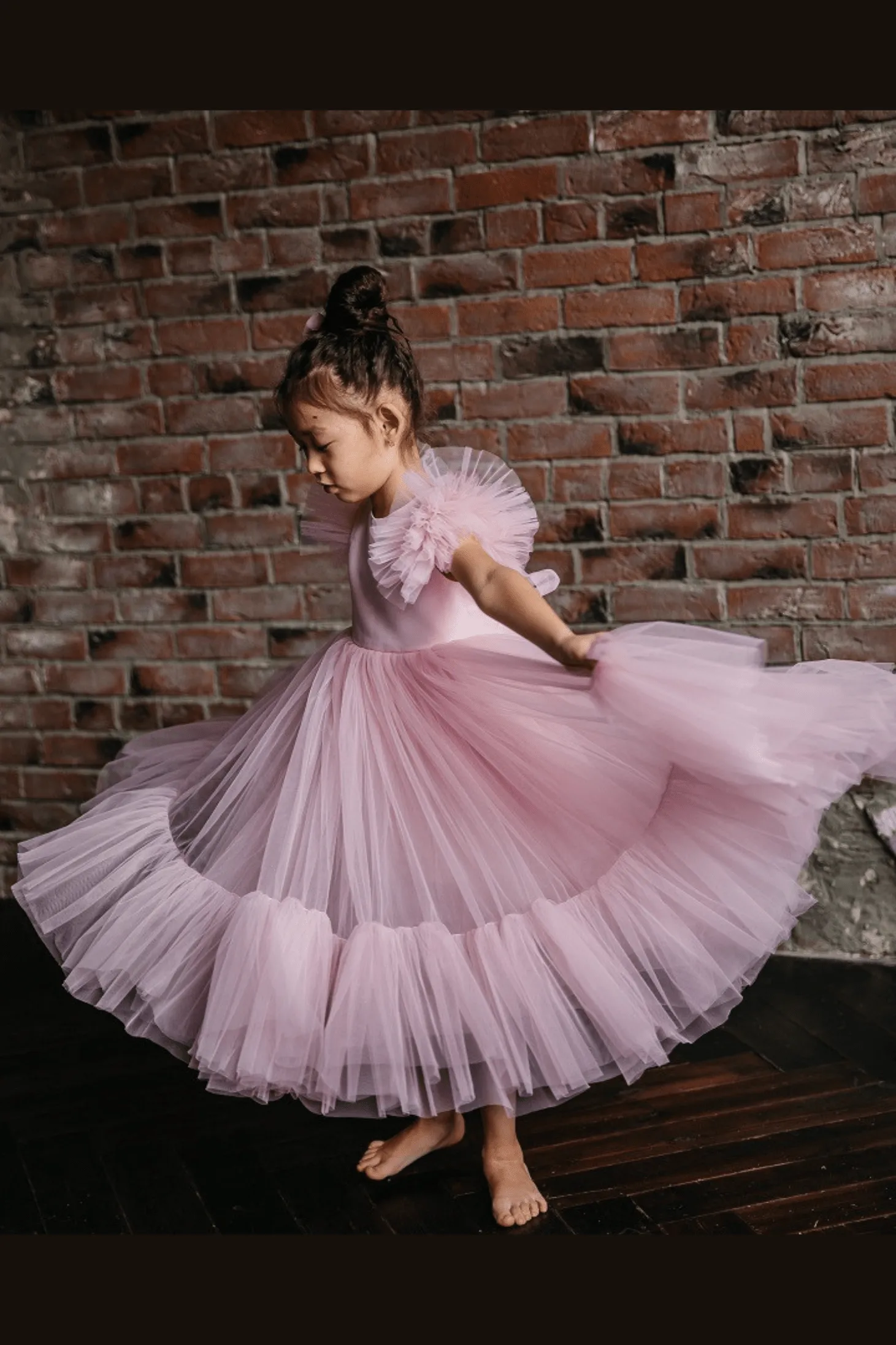 Abito bimba rosa con maniche a ventaglio e gonna in tulle multistrato rifinita da volants